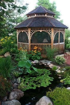 a gazebo in the middle of a garden with water lilies