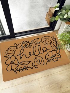 a door mat with the word hello written in black ink on it next to a potted plant