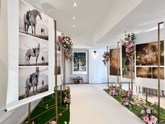 a hallway with flowers and pictures on the wall next to grass in front of it