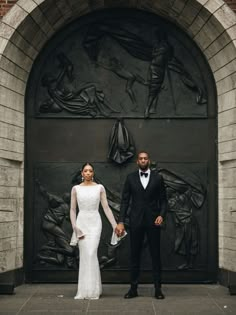 a bride and groom standing in front of an art deco door at their wedding reception