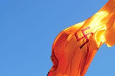 an orange flag flying high in the sky