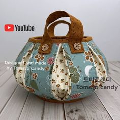 the purse is made from fabric and has buttons on it's front end, which are decorated with flowers