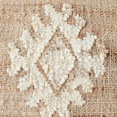 an old rug with some white flowers on it