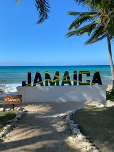 a sign that says jamaica in front of the ocean