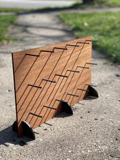 a wooden sign sitting on the side of a road next to a grass covered field