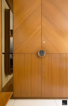 a wooden door with a round knob on it's side in front of a white tiled floor