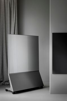 a black and white photo of a laptop on a table next to a gray wall