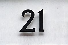 the number twenty two is shown in black on a white wall with numbers below it