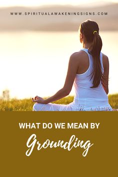 a woman sitting in the grass with her arms crossed, looking at the water and text that reads what do we mean by grounding