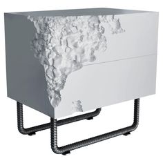 a white cabinet with some black pipes on the bottom and one drawer that is covered in snow