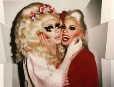 two women dressed as marilyn monroe and one with makeup on her face hugging each other