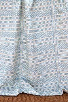 a blue and white checkered blanket on the floor