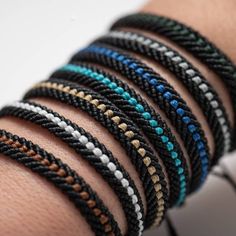 a close up of a person's arm with several different bracelets on it