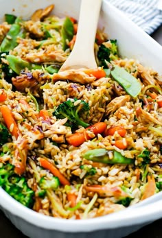 a white bowl filled with rice, broccoli and carrots