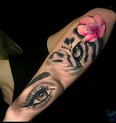 a woman with a tiger eye and flower on her arm