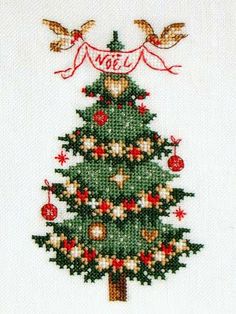 a cross stitch christmas tree with birds on it