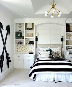 a bed room with a neatly made bed and lots of bookshelves on the wall