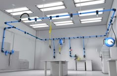 an empty room with blue pipes running from the ceiling to the floor, and white walls