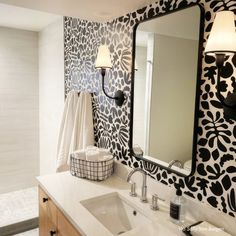 a white sink sitting under a bathroom mirror next to a wall mounted faucet