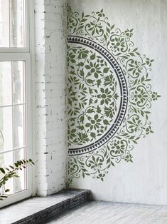 the wall paper is designed to look like an intricate flower ornament, and has been stenciled with green leaves