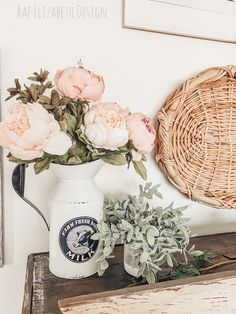 some flowers are in a white vase on a shelf next to a basket and other items