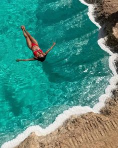 a woman is swimming in the clear blue water