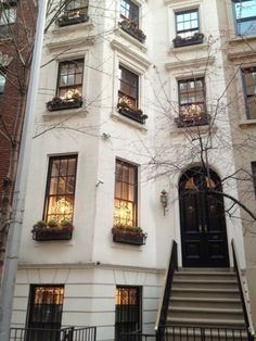 an apartment building with many windows and stairs leading up to the front door, in new york city