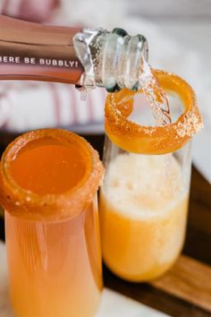 an orange juice is being poured into a glass with a pretzel in it