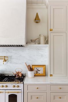 a kitchen with marble counter tops and gold trim on the oven, cabinets, and stove hood