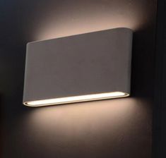 a white wall light mounted on the side of a wall