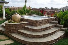 an outdoor hot tub surrounded by stone steps