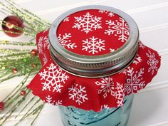 a mason jar with red and white snowflakes on it