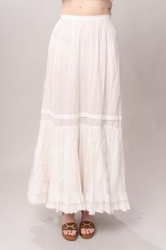 Stunning Edwardian 1910’s white cotton and lace maxi petticoat skirt. With a pretty flare silhouette, panel lace detail, and a button closure at waist. Good vintage condition, with normal wear and condition for its age. Some areas of visible mending a minor staining - see pictures. Best fits modern size XS/S Waist 26”Length 42” Featured top is the Blue Doll Quilt Corset from our friends at Psychic Outlaw. Model’s Measurements:Height 5’9”Chest 34”Waist 29”Hips 36.5” White Lace Patchwork Long Skirt, Daywear Long Lace Skirt, White Lace Vintage Bottoms, Vintage White Lace Bottoms, White Vintage Lace Bottoms, Vintage White Bottoms For Wedding, Vintage Long Lace Skirt, Lace Trim Maxi Skirt For Wedding, Flowy Wedding Maxi Skirt With Lace Trim