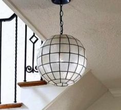 a chandelier hanging from the side of a stair case