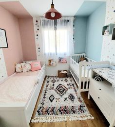 a baby's room with two cribs and a rug on the floor