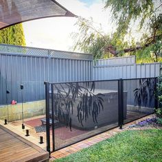 a fenced in backyard area with an umbrella over it