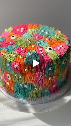 a multicolored cake sitting on top of a white plate