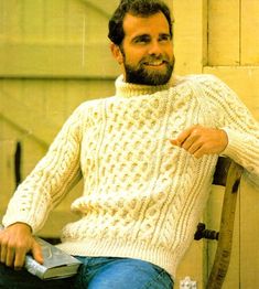 a man sitting in a chair wearing a sweater