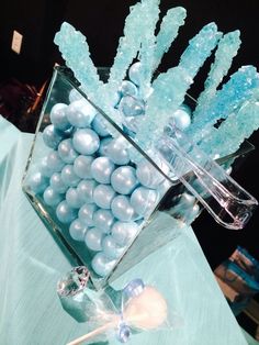 a glass vase filled with blue and white candies