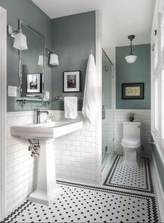 a bathroom with black and white tile flooring and walls, along with a pedestal sink