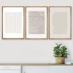 three framed art prints hanging on the wall above a white dresser with a potted plant