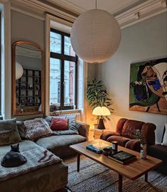 a living room filled with furniture and a large painting hanging on the wall above it