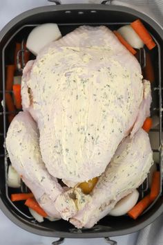 a whole chicken in a roaster with carrots and celery