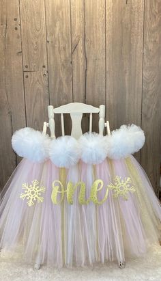 a white chair with pink and gold tulle skirt