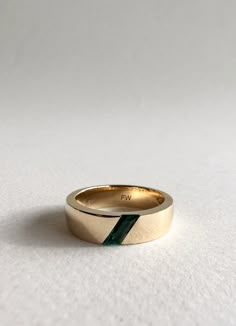 This 6mm wide men's wedding band features a stunning Parallelogram emerald stone sitting on an angle, with custom engraving on the inside of the band. Set in yellow gold Men’s Gemstone Wedding Ring, Emerald Male Wedding Band, Mens Wedding Bands With Emeralds, Male Wedding Bands Emerald, Men’s Emerald Engagement Rings, Men’s Wedding Bands With Stones, Men Engagement Ring Unique, Cool Men Wedding Band, Men’s Wedding Band With Emerald