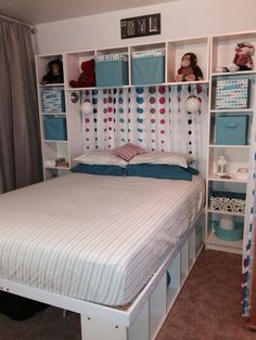 a bedroom with a bed, bookcases and toys on the shelves above it