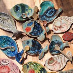 many different types of bowls and spoons on a wooden table with wood flooring