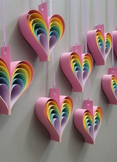 paper hearts hanging from hooks on a wall