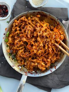 a pan filled with noodles and vegetables on top of a table