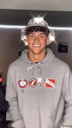 a young man wearing a crown standing in front of a wall with other items on it